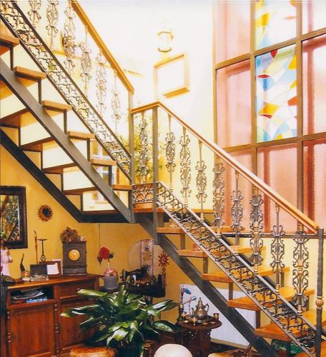 a spiral staircase in a living room with a clock at Dormir en Cádiz in Cádiz