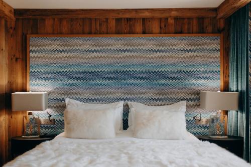 a bedroom with a bed with white pillows and two lamps at Armancette - The Leading Hotels of the World in Saint-Gervais-les-Bains