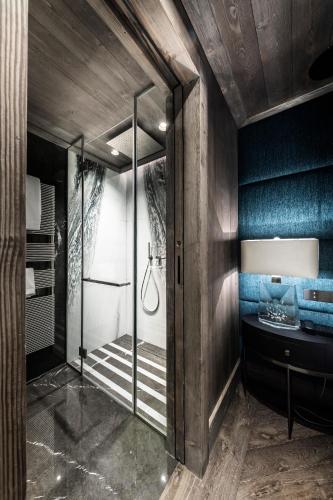 a bathroom with a walk in shower and a glass door at Armancette - The Leading Hotels of the World in Saint-Gervais-les-Bains