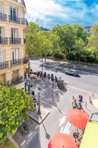 - une vue sur une rue avec des parasols et un bâtiment dans l'établissement Hôtel Capfun Le Saint Germain, Paris, à Paris