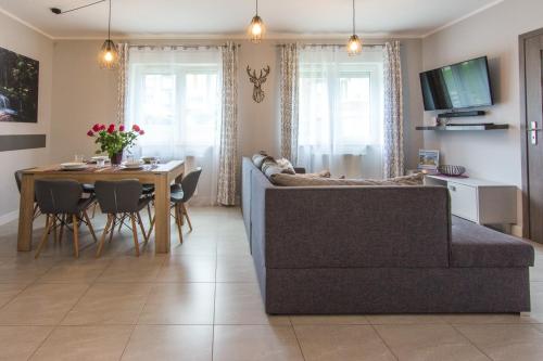 a living room with a couch and a table at Apartamenty Izerskie - ul. Cicha 13F-G in Świeradów-Zdrój