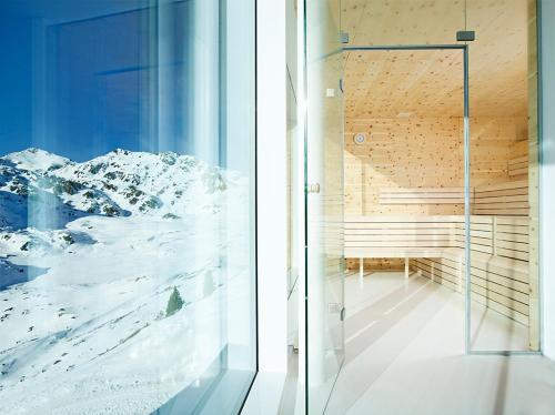 a room with a glass door and a snowy mountain at Kristallhütte in Zellberg