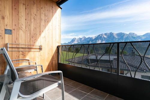 a balcony with chairs and a view of mountains at Apart & Suiten Hotel WEIDEN in Schladming
