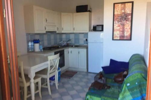 a kitchen and a living room with a table and a couch at Mare, dune, lago e bosco in assoluto relax. in Torre Dei Corsari