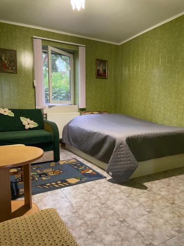 a bedroom with a bed and a green wall at Constancia in Kamianets-Podilskyi