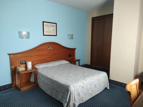 Habitación de hotel con cama y teléfono en Hotel Ébora by Vivere Stays, en Talavera de la Reina