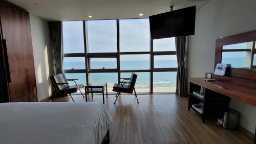 a bedroom with a bed and a table and chairs at MS Hotel Haeundae in Busan
