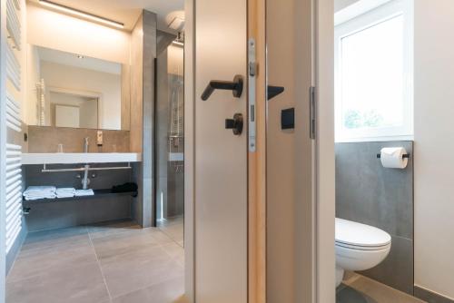 a bathroom with a toilet and a sink at Apart & Suiten Hotel WEIDEN in Schladming