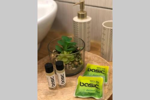 La salle de bains est pourvue d'un lavabo et de 2 produits sur une table. dans l'établissement Studio Cosy 2 PERS, à Longjumeau