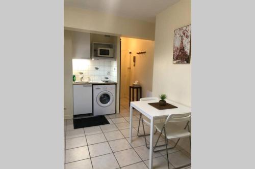 une cuisine avec une table et une machine à laver dans l'établissement Studio Cosy 2 PERS, à Longjumeau