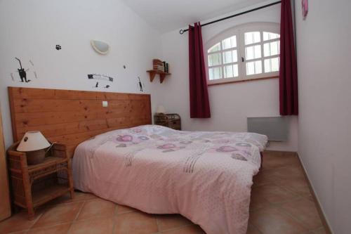 Un dormitorio con una cama grande y una ventana en Gîte avec piscine et climatisation, en Buzignargues