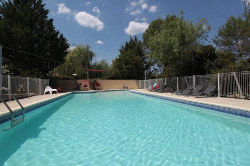 une grande piscine avec de l'eau bleue dans l'établissement Gîte avec piscine et climatisation, à Buzignargues