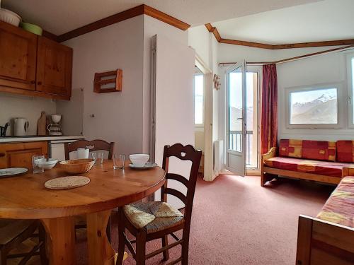 une cuisine et une salle à manger avec une table et des chaises dans l'établissement travelski home classic - Résidence Médian, aux Menuires