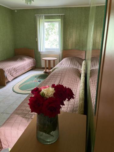 a bedroom with a bed and a vase of flowers at Constancia in Kamianets-Podilskyi