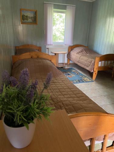 a bedroom with a bed and a table with purple flowers at Constancia in Kamianets-Podilskyi