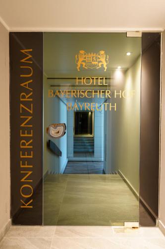 a glass door with a sign for a hotelkeeper hog payment at Hotel Bayerischer Hof in Bayreuth