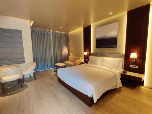 a bedroom with a large white bed in a hotel room at Radisson Blu Resort Visakhapatnam in Visakhapatnam