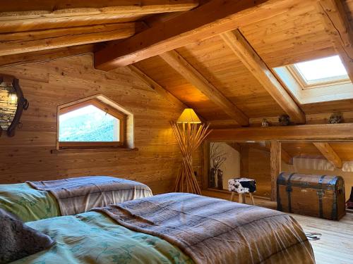 a bedroom with two beds in a log cabin at Frazione Duc Apartments in Sestriere