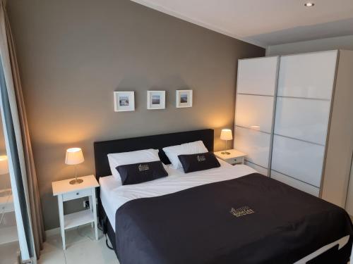 1 dormitorio con 1 cama con 2 almohadas en BONNIES Beach & Spa DuinNest, en Cadzand-Bad