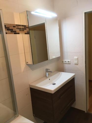 a bathroom with a sink and a mirror at Ferienwohnung Im Moos in Oberstaufen