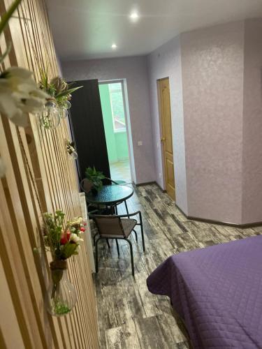 a room with a purple bed and a table at Constancia in Kamianets-Podilskyi