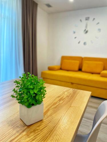a living room with a table and a yellow couch at Sunrise Aparts in Polyana