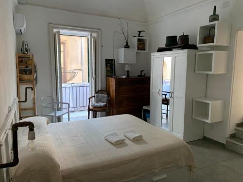 um quarto branco com uma cama e um frigorífico em FraLePorte em Palermo