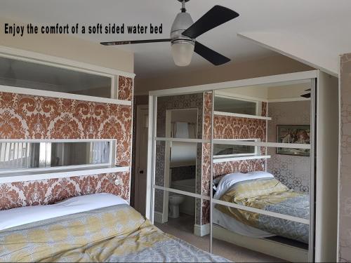a bedroom with two bunk beds and a ceiling fan at The Mystical Orchard in Holywell