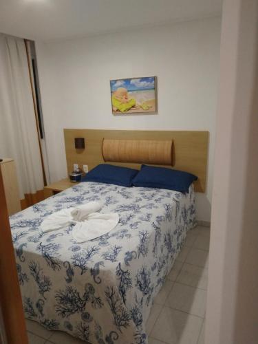 a bedroom with a bed with a blue and white bedspread at Beach Class Muro Alto Porto de Galinhas in Porto De Galinhas