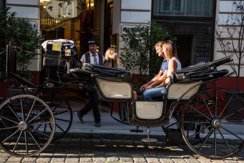 a group of people sitting in a horse drawn carriage at Theaterhotel & Suites Wien in Vienna