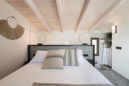 a bedroom with a bed with two mirrors above it at Casa Nostos in Agia Marina Nea Kydonias