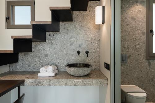 a bathroom with a bowl sink and stairs at Casa Nostos in Agia Marina Nea Kydonias