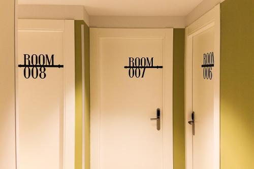 two white doors with the words roomox and the words runidas at Room018BCN in Barcelona