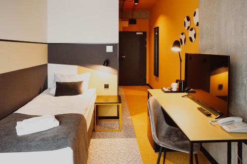 ein Hotelzimmer mit 2 Betten, einem Schreibtisch und einem Computer in der Unterkunft Arche Hotel Piła in Piła