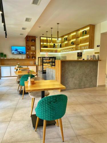 a restaurant with wooden tables and green chairs at Sunrise Aparts in Polyana