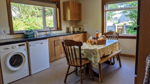 a kitchen with a table and a washing machine at Remuera, North Tolsta in North Tolsta