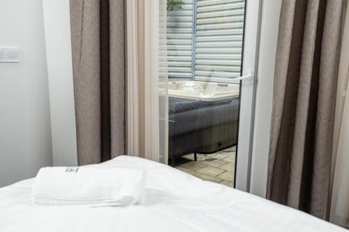a bedroom with a bed and a window with a view at Arena Deluxe & Spa in Szeged