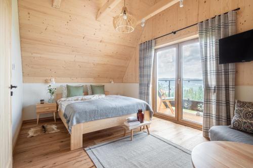 sypialnia z łóżkiem i dużym oknem w obiekcie Domki Górski & Polny Kwiat w Zakopanem