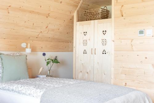 a bedroom with a bed and wooden walls at Domki Górski & Polny Kwiat in Zakopane