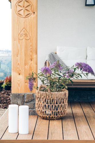 a wicker basket with purple flowers sitting on a table at Domki Górski & Polny Kwiat in Zakopane