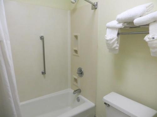 a bathroom with a shower and a toilet and towels at Baymont Inn & Suites by Wyndham Florence in Florence