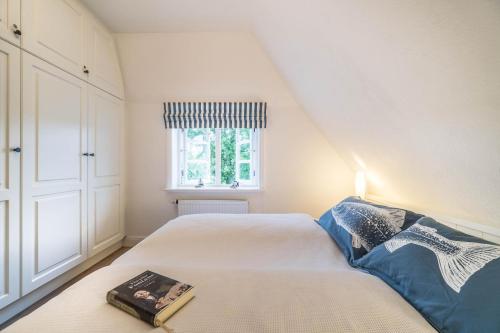 a small bedroom with a bed and a window at Altes Schulmeisterhaus Wohnung 2 in Oevenum