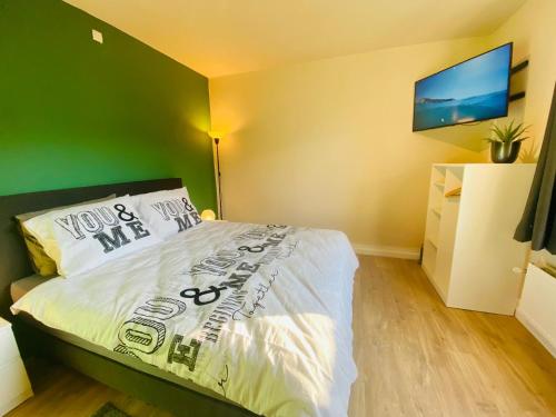 a bedroom with a bed with a green wall at Brasserie & Logies De Pijl in Mechelen