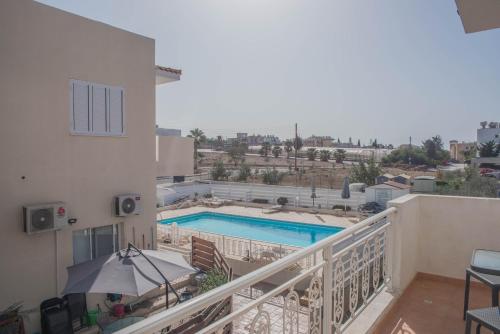 PaphosにあるRenovated one bedroom apartment in Paphos with poolのスイミングプールを望むバルコニー