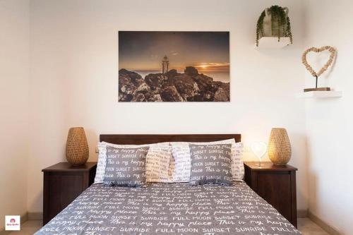 1 dormitorio con 1 cama y una pintura en la pared en Vv López-Aguilar, en La Frontera