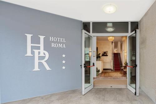 pokój hotelowy z znakiem hotelu roma na ścianie w obiekcie Hotel Roma w Palmanovej