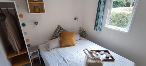 a small bedroom with a bed with a window at Camping du Lac in Marcillac-la-Croisille