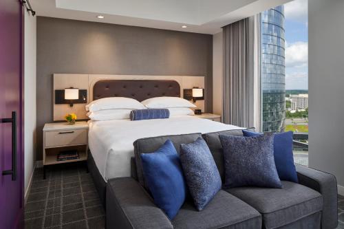 a bedroom with a large bed and a couch at The Watermark Hotel in Tysons Corner