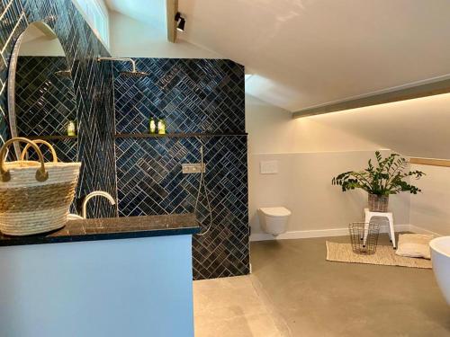 y baño con lavabo, aseo y barra. en Luxe Loft voor 4 personen en Reutum