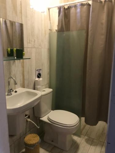 uma casa de banho com um WC, um lavatório e um chuveiro em Pousada o Mineiro Central em Galinhos